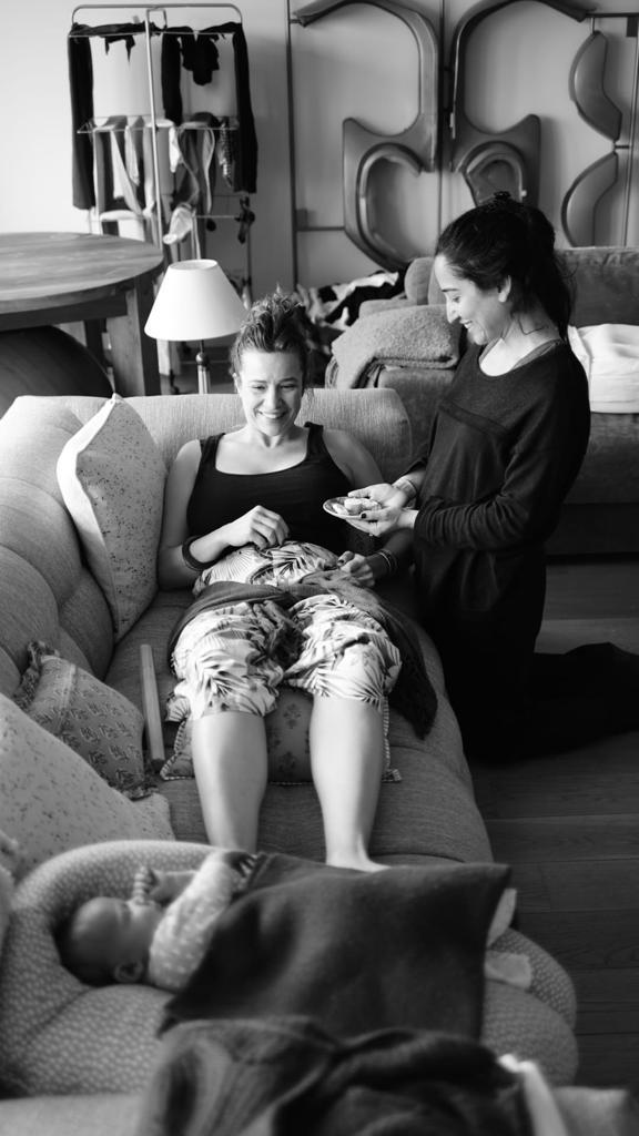 Doula accompagnant une jeune mère à domicile après la naissance